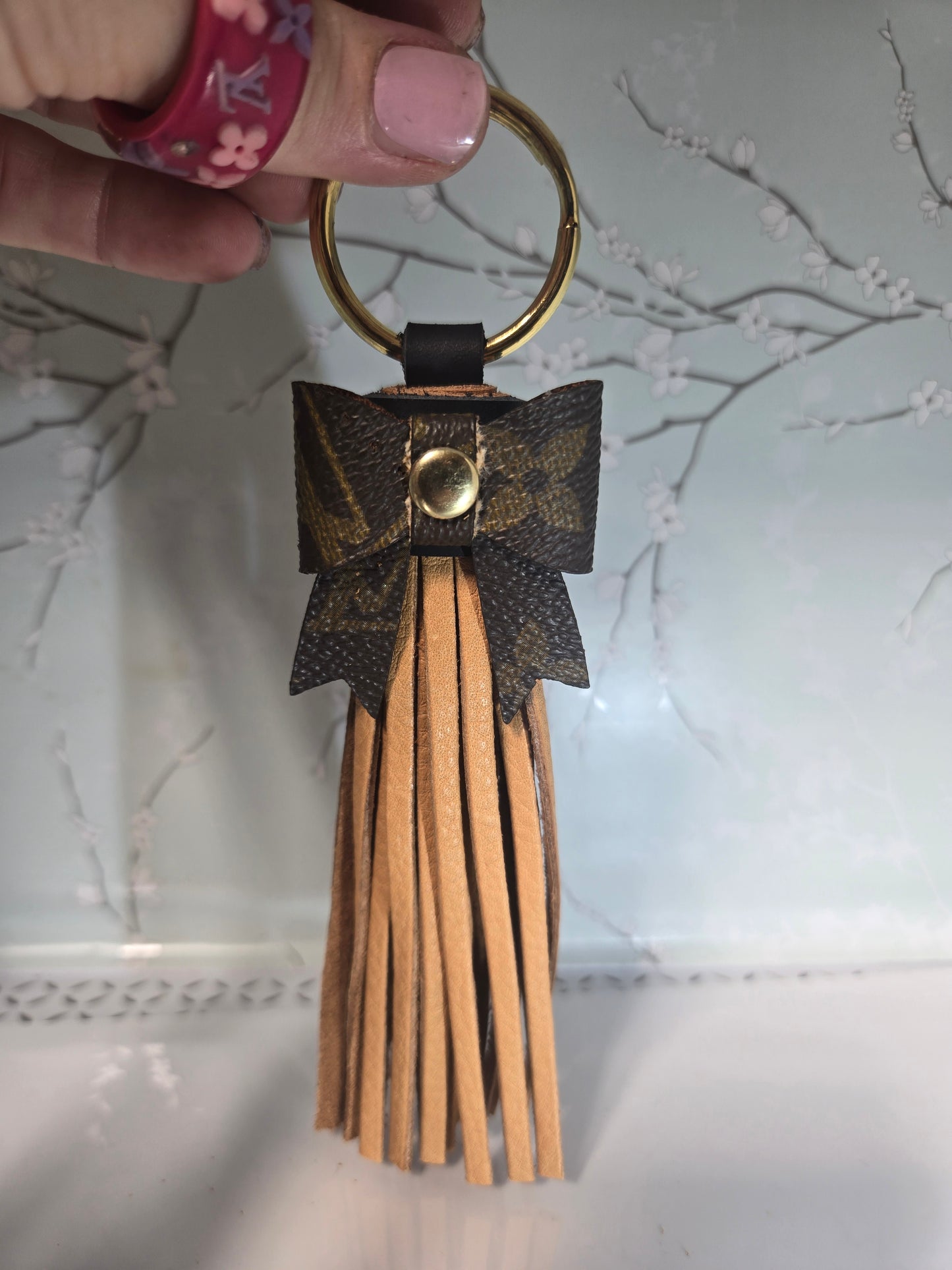 Upcycled leather tassle bow.