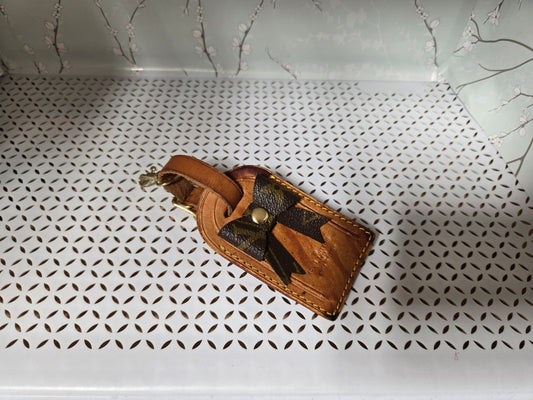 Authentic luggage tag with upcycled bow bag charm. HAS STAINS AS IS.